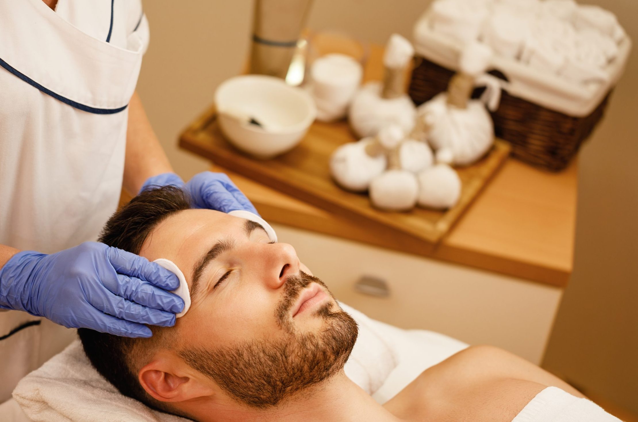 young man receiving facial treatment at the spa.